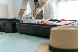 Woman packing suitcase on bed for a new journey packing list for travel planning preparing vacation Book Now Traveling Transportation photo