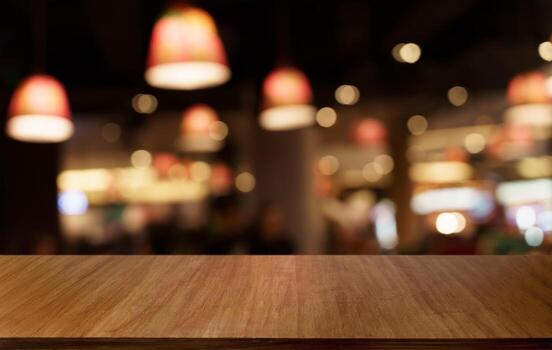Mock up for space. Empty dark wooden table in front of abstract blurred bokeh background of restaurant . can be used for display or montage your product photo