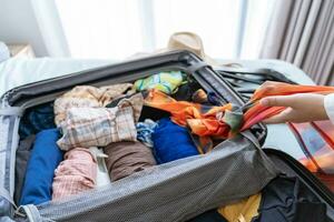 mujer embalaje maleta en cama para un nuevo viaje embalaje lista para viaje planificación preparando vacaciones libro ahora de viaje transporte foto