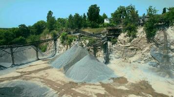 Arial view of the sand making plant in open-pit mining. Drone flies over excavators and tractor loading crushed stone and rock into dump truck. 4k stock footage. video