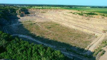 Arial vue de le le sable fabrication plante dans mine à ciel ouvert exploitation minière. drone mouches plus de pelles et tracteur chargement écrasé pierre et Roche dans déverser camion. 4k Stock images. video