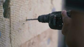 Arbeiter Bohrer ein Mauer mit ein elektrisch bohren video