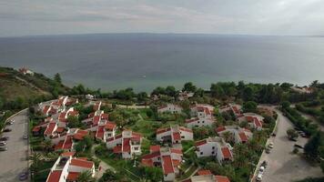 Resort area with cottages on the coast of vast blue sea, aerial video