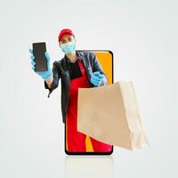 Delivery man in cap k t-shirt uniform face mask gloves hold cardboard box isolated on color background. Service quarantine pandemic coronavirus virus 2019-ncov concept photo