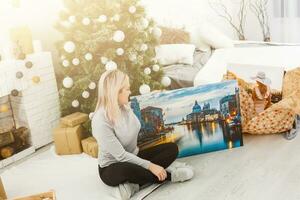 girl holds photo canvas as a christmas present