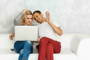 Couple using a notebook while relaxing on the couch photo