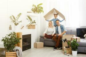 Happy family with cardboard boxes in new house at moving day. photo