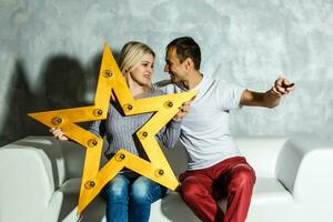 Young man watching tv with his wife at home photo