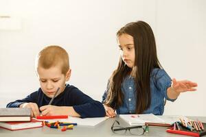 Portrait of two kids looking at workplace with schoolboys on background photo