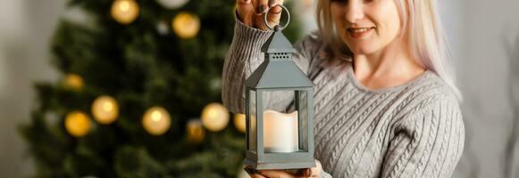 woman near christmas tree with christmas lantern photo