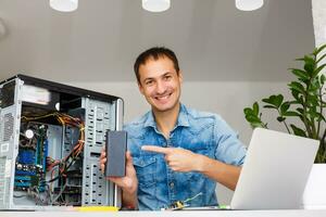 Man using laptop to check servers in data center photo