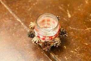 Winter holidays christmas decor. Candescent made of glass jar and pine cones. Top view photo