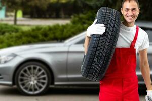 Mechanic holding a tire tire at the repair garage. replacement of winter and summer tires. photo