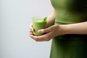 Beautiful girl holding a green drink from Moringa photo