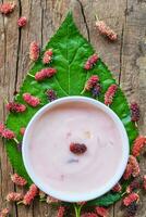 Yogurt Mulberry in bowl on green leaf mulberry photo