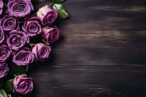 beautiful purple roses on dark wooden background top view, floral template with copy space photo