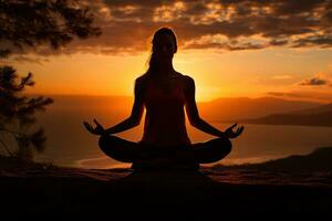 silhouette of a woman doing yoga in the mountains at sunset or sunrise, meditation in nature photo