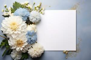 mockup square white blank card sheet of paper with white and blue dahlia flowers and leaves photo