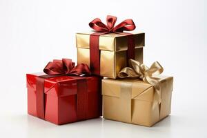 Three gift boxes wrapped in red gold shiny decorative paper tied with ribbons on white background photo