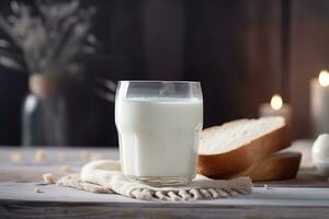 Glass of milk and sliced freshly baked white bread on blurred kitchen background photo