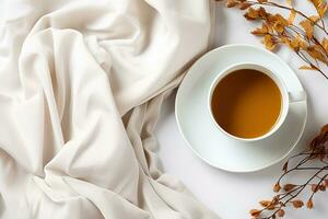 top view of breakfast coffee cup surrounded by dry plant stems and wrinkled white cloth photo