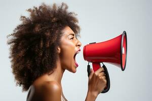 Young curly African woman shouting into a red megaphone on a white background. photo