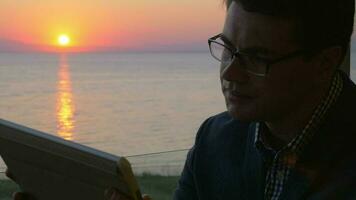 Man working with pad on the balcony at sunset video