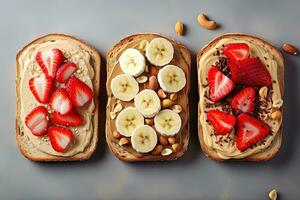 set of three morning toasts with peanut butter strawberry and banana on a gray concrete background flatlay photo