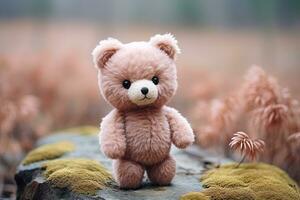 cute pink teddy bear standing on a stone on a blurred background photo