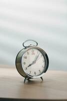 old mechanical alarm clock on wooden table in a living room. photo