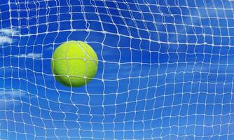 tennis ball into the net sky background photo