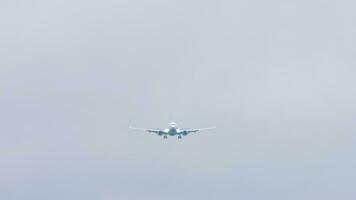 Airliner approaching landing in the gray sky. The plane flies in the sky in cloudy weather video