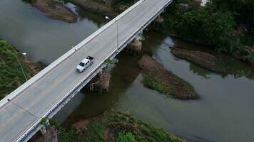 chiang mai el puente terminado el silbido río. aéreo ver de el tráfico en el puente terminado el río. video