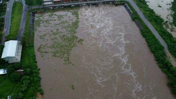 antenn se av de vatten släppte från de betong dammens dränering kanal som de svämma över i de regnig säsong. topp se av grumlig brun skog vatten flöden från en damm i lantlig nordlig thailand. video