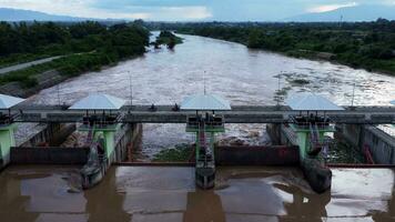 vue aérienne de l'eau libérée du canal de drainage du barrage en béton est un moyen de déborder de l'eau pendant la saison des pluies. vue de dessus de l'eau de la forêt brune trouble s'écoule d'un barrage en thaïlande. video