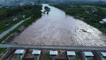 antenn se av vatten släppte från de dränering kanal av de betong damm är en sätt av överfyllda vatten i de regnig säsong. topp se av grumlig brun skog vatten flöden från en damm i thailand. video