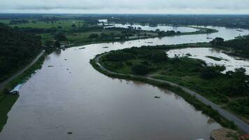 antenne visie van de water vrijgelaten van de beton moeders afvoer kanaal net zo de overloop in de regenachtig seizoen. top visie van troebel bruin Woud water stromen van een dam in landelijk noordelijk Thailand. video