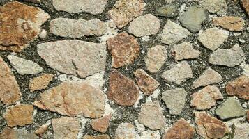 albañilería pared pavimentación piedra, áspero natural Roca hormigón cementado como fondo y fondo, medio años estilo. foto