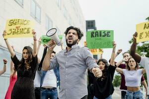 Man screaming through megaphone while protesting with people on street in city photo