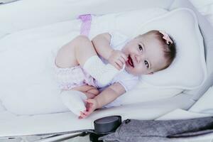 Happy baby girl lying in stroller photo