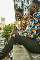 Friends sitting on roof terrace in the city drinking beer, Maputo, Mozambique photo