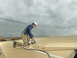 Austria, construction worker fixing medium-density fibreboard photo