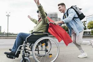 Young man pushing senior man sitting in a wheelchair dressed up as superhero photo