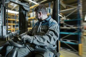 Fork-lift driver in motion in storehouse photo