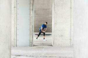 Man stetching at an underpass photo