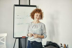 Smiling businesswoman leading a presentation at flip chart in conference room photo