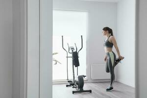 Woman performing stretching exercises before a workout at home photo