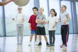 Pupils in gym class looking at teacher photo