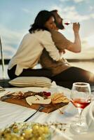 Couple having picnic on jetty at a lake at sunset photo