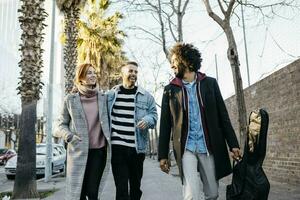 Three happy friends walking in the city photo